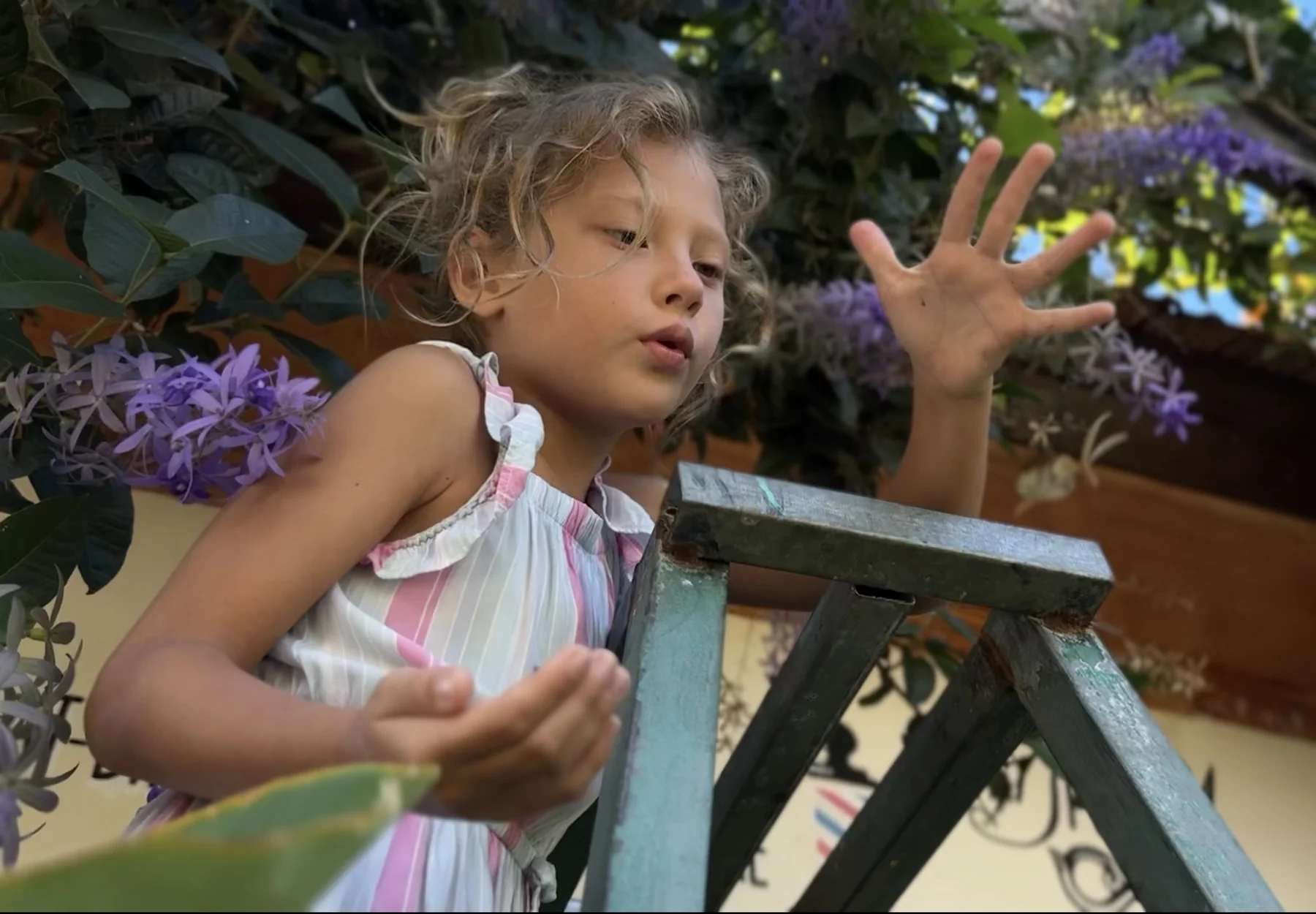 Jaya gesturing while talking among flowers