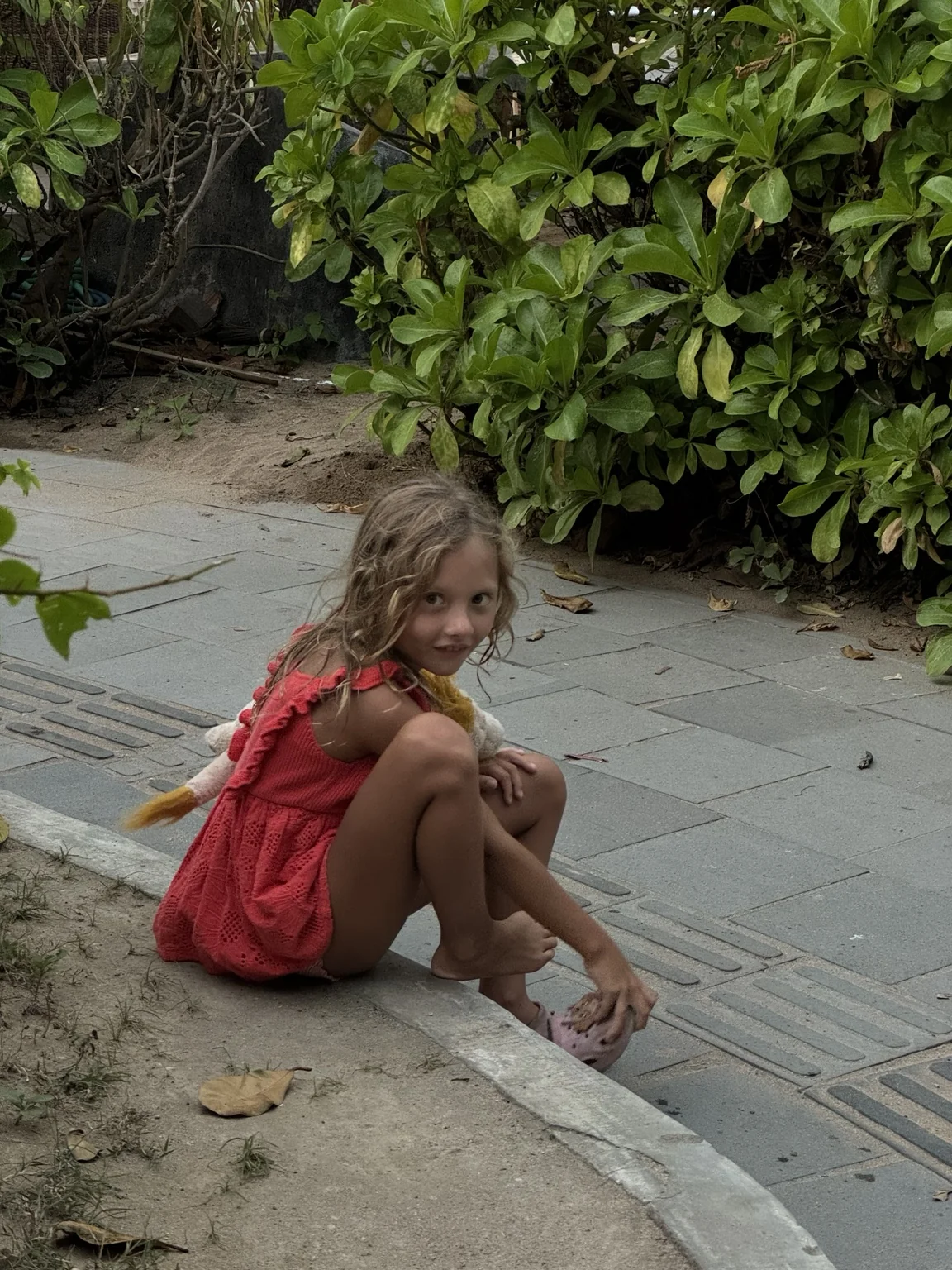 Jaya sitting outside in a red dress