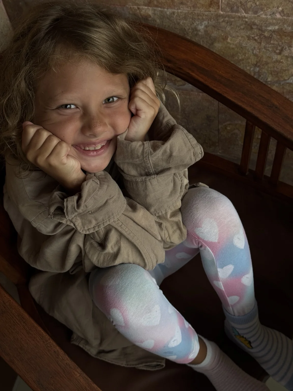 Jaya smiling naturally in a chair